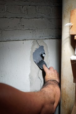 Tony begins spreading the paste around the port to seal it in. Epoxy paste has a short working time, which helps stick the ports in place.