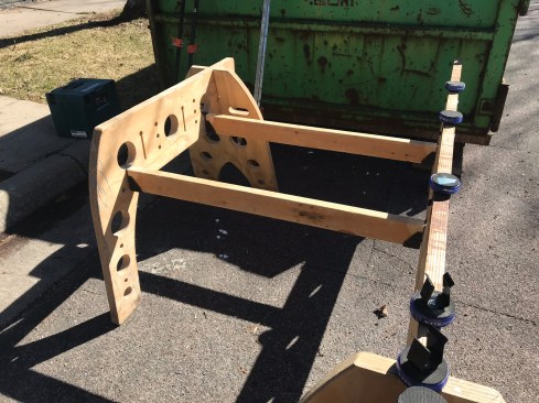 Metal brackets for holding 2x4s clip into the rail holes to create a support table where the author typically places a table saw. The disks on the right-hand rail are rubber-topped Rockler “bench cookies,” which clip to the rail to provide an additional work surface. 