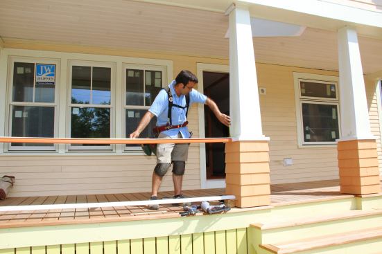 Pollard measures the distance from post to post in order to determine where mark the center of the opening on the ralis for his baluster layout.
