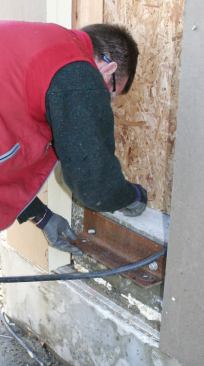 Sections of 3 1/4-inch by 3 1/4-inch by 1/4-inch steel angle were bolted to the wall underneath the door openings.