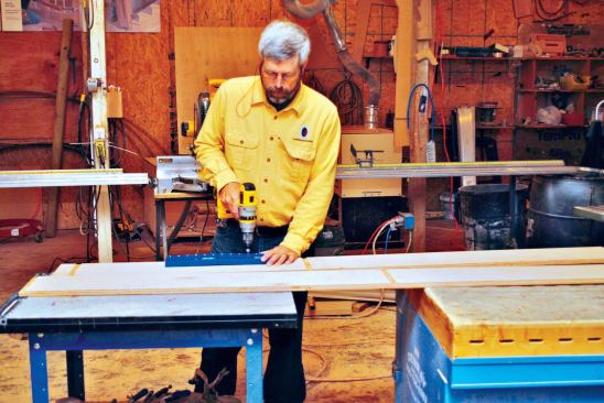 Shelf-pin holes are drilled in the sides of the cabinet case with the help of a jig.