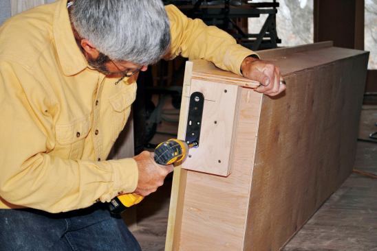 Two layers of 3/4-inch plywood pad out the plate on the bottom of the cabinet to create proper clearance between the cabinet and the floor.