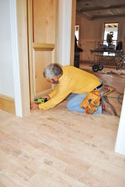 The door casings cover the gap between the cabinet and the wall. The pilaster trim and plinth block are fastened to the wall on the hinge side, and to the cabinet on the “latch side,” where they also act as stops for the door.