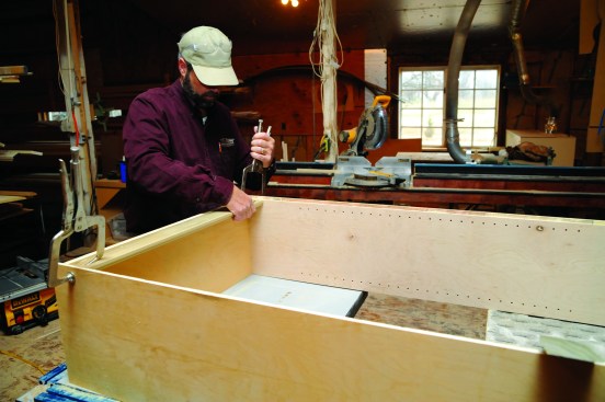 The author pocket screws a stretcher rail at the top of the cabinet for a place to attach the cabinet back as well as for a place to attach the cabinet to the wall.