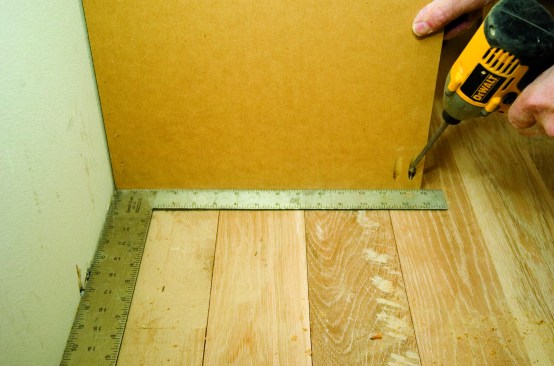 Pocket screws can be used instead of toenails for strong connections. Here the side of a cabinet panel is screwed to the floor.