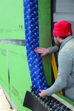 The lower portion of the jamb flashing lapped over the upturned sill flashing. The inner edge of the tape was positioned to be inside of the window's exterior face.