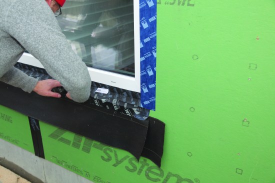 Once the top of the tape was adhered to the window frame, the rest of it was adhered to the dam and to the sill flashing tape.