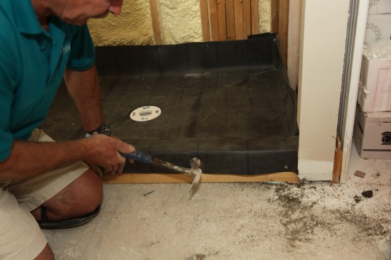 Carefully fold the flap inside the shower and attach it to the framing with a nail 2 inches above the threshold. Nail the membrane to the outside of the threshold. No nails should be driven on the inside or through the top of the threshold. 