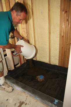 Dump several buckets of dry-pack mortar (the same mix that was used to create the sloped layer) onto the membrane.