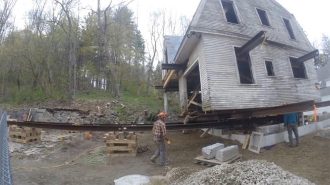 Here, a video still from the author’s GoPro camera shows the building nearly placed on its new foundation.