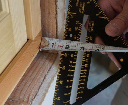 The first step in casing a window is measuring for the jamb extensions, pieces of wood that extend out from the window frame, flush with the interior wall surface. Measure at each corner and record the measurement.