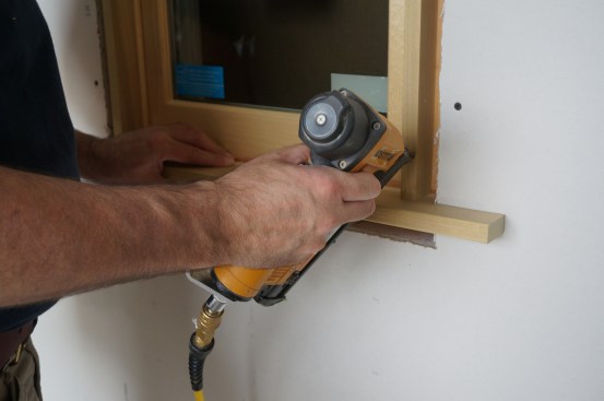 After running a bead of glue around the extension jambs, drive nails to hold the assembly in place.
