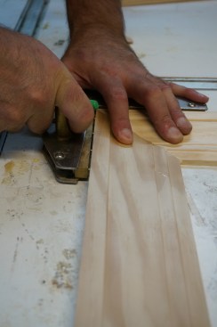After slathering glue on the biscuit as well as the slot and the mating miter surfaces. clap the corner joint with a clam clamp, which provides the necessary pressure for the glue to cure properly.