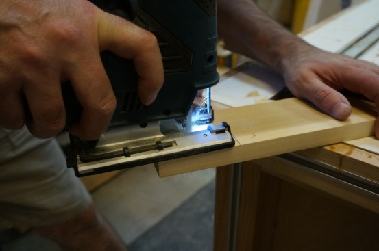 Using a jigsaw, follow the scribe lines to create the horns on the stool stock.