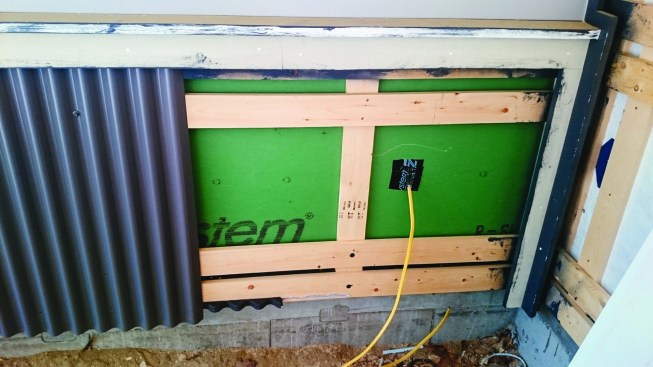 A second horizontal layer of furring provides nailing for vertically applied siding, such as this corrugated metal.