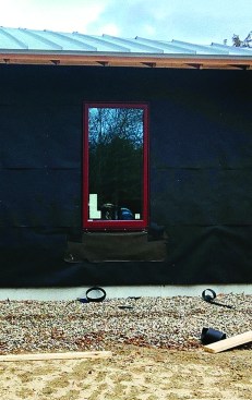 A flap of building paper below the window layers into the building paper of the open rainscreen so that it sheds water properly.