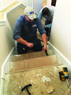 After removing the carpet and tack strips from the treads and risers, the author carefully removes the original underlayment treads.