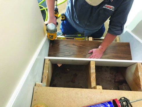 He levels the tread in two directions using either narrow cedar shims or shims cut from 2x4s with a FastCap Fast Shim jig. Locked in place with the adhesive, the shims help to hold the treads level and compensate for any shrinkage in the stair stringers. After shimming the tread properly in both directions, he fastens the treads to the stringers using 15-gauge finish nails.