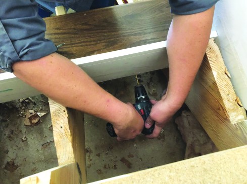 The author attaches each tread to the riser above from the back. First, he drills holes for the fasteners.