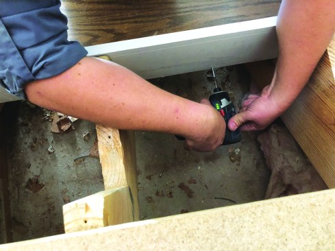 Then he drives three square-drive truss-head screws on either side of the center stringer. These screws work with the wood glue both to keep the back of the tread from opening up and to prevent the stairs from squeaking.