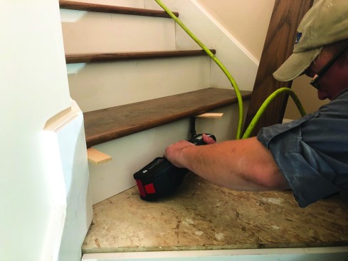 When the treads are secured in place, he trims off any remaining shims.