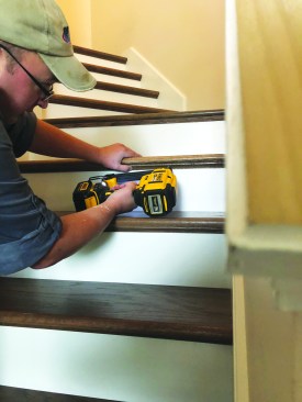 The final step is installing prestained cove molding under each tread nosing using wood glue and 18-gauge finish nails. The remodeled stairs are then ready for service.