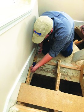 After removing the fasteners from them, the author sets them aside to be installed as temporary treads. With the treads and risers removed, he cleans off any residual adhesive from the stringers.