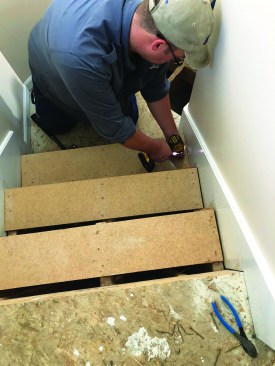 He then screws the risers down as temporary treads to allow the crew and the homeowners to use the stairs.