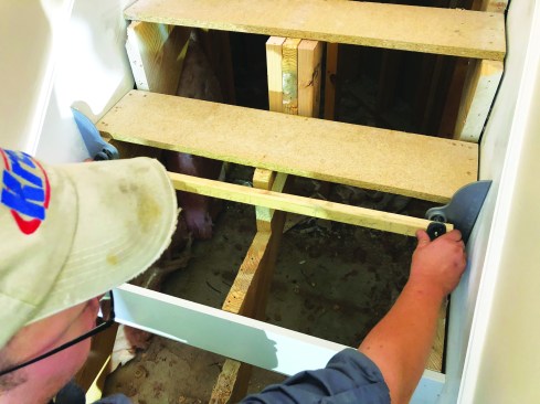 To remodel the stairs, the author begins by removing the first three or four temporary treads. He then uses a Collins Tool Co. stair-tread templating tool to gauge each riser with the tool carefully labeled to keep the orientation straight.