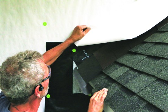 Drop the flap of WRB back down over the step flashing along the roof-wall intersection.