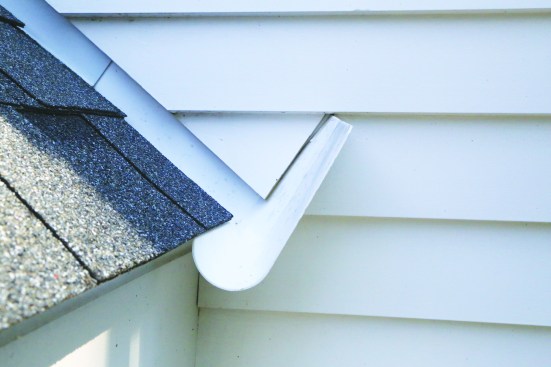 Slots or notches in the siding allow it to fit around the kickout flashing. The layers behind the flashing should protect against any water that might get through.
