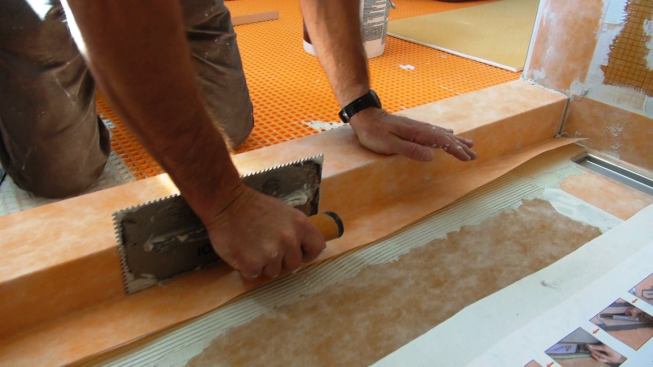 Boucher presses the membrane down into the mortar using a float, to create a firm, positive bond.