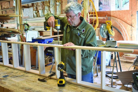 He then flips the assembly over and attaches the other rail.