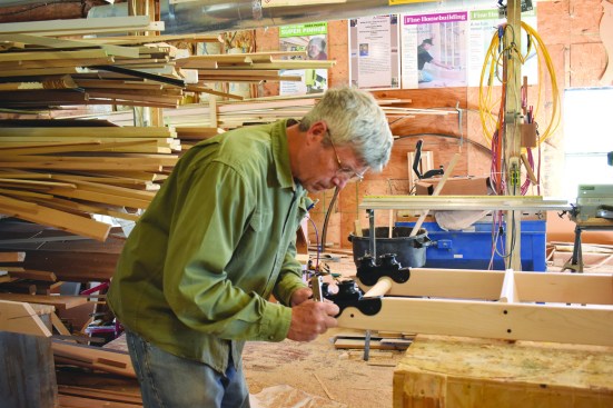 The author attaches the roller hardware to the tops of the ladder rails.