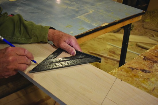 Then he draws layout lines with a rafter square.
