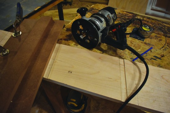 A stepped jig guides a router to cut the dadoes.