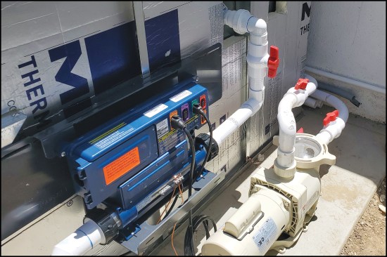 Figure 11. The unit is fitted with a “Gecko” water-quality/heat controller (blue) and filter motor. Here, the white pump powers hydrotherapy jets, while the pump that powers the filtration/electric heater is to the left of the Gecko (not shown in the photo).