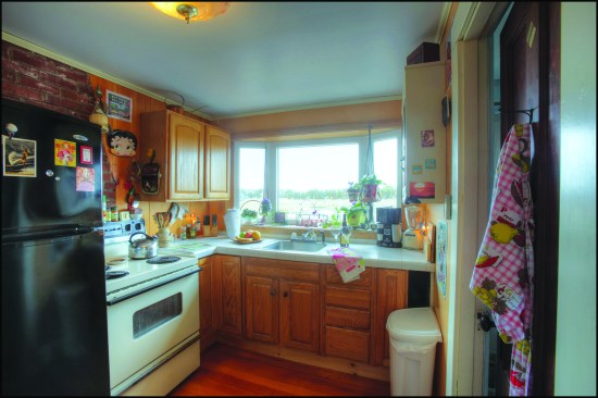 Before. Last renovated in the 1990s, the existing kitchen had full-size appliances, a tile countertop, and stock cabinets that left an open space on one side that was barely usable.