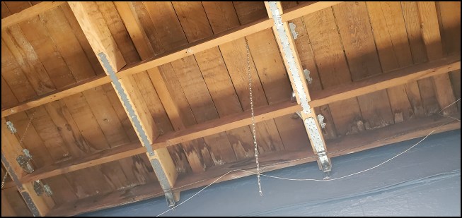 Roof connections. Between rafters parallel to the wall, 4-by blocking was added and secured with metal strapping and tension ties.