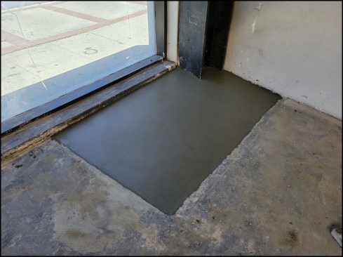 Moment frame. A second concrete pour buries the column base plates and is troweled smooth.