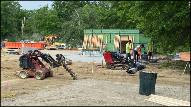 A Toro Dingo with an auger powerhead (at left) bored 8-inch holes for the post footings.