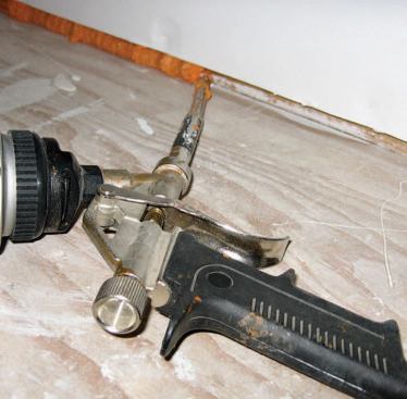 An intentional 1/4-inch gap below the drywall on exterior walls is easily filled with canned foam. In a retrofit project, it’s a good idea to protect the finish floor with paper or tape first.