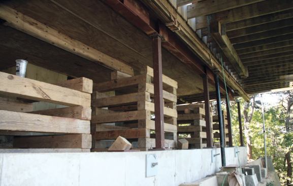 The steel I-beam was then jacked into place and welded to the tops of the columns.