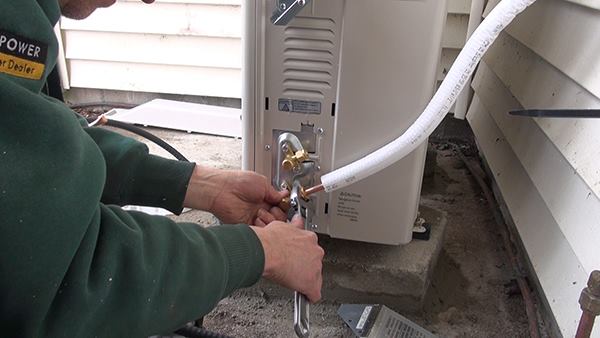 Outside, Dave Ragsdale hooks refrigerant lines up to the outdoor compressor unit of the system. The unit comes pre-charged with R-410a refrigerant, but the refrigerant won’t be released into the copper lines until after the lines have passed a 600-pound overnight pressure test using compressed nitrogen.