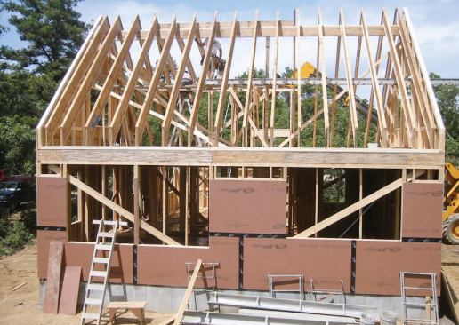Taped Zip System sheathing — applied continuously on the walls, over the plumb-cut rafter ends, and up the slope of the roof — provides the primary air barrier.