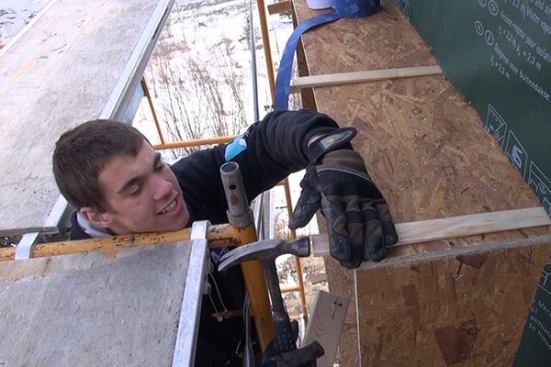 EcoCor carpenter’s helper Evan Drinkwater shims down an extension window buck for an existing window in the Newcastle “Ripple” house. Accurate, square, plumb, and level window openings are important, because the manufactured Passive House windows will need to be installed carefully into the openings.