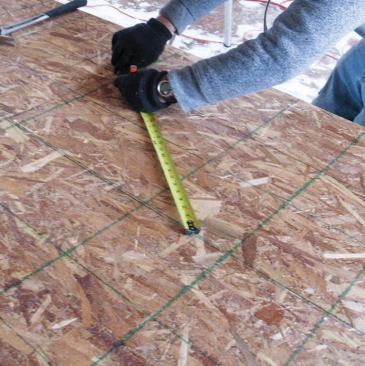 Front Wall: We laid out the front wall sheathing, pulling the radius for the arch-top window with a measuring tape.