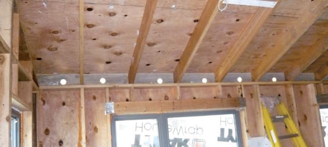 Holes bored in the rafter blocks provided access to the closed framing cavities after the drywall had been hung.