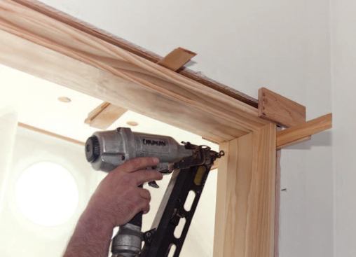 Once the hinge jamb is permanently installed, the top of the latch jamb is shimmed and pinned to the framing with a finish nail.