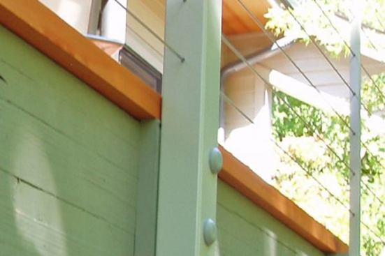 Cable railing can be held in place by site-built wood or metal posts Metal posts come in both tubular and rectangular profiles, and are often bolted to the outside of the fascia, as shown here. These posts can be topped with either metal or wood rails, depending on the manufacturer's options.